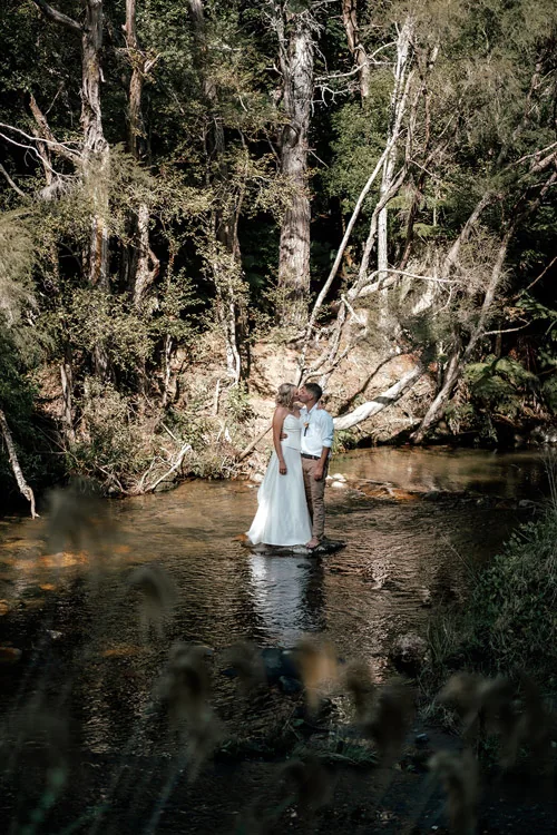 Real wedding featuring a convertible wedding dress in a forest stream setting – Auckland, New Zealand.