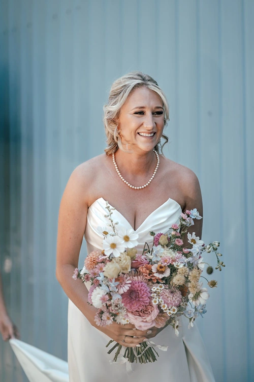 Smiling bride in strapless convertible wedding dress with structured satin bodice – Auckland, New Zealand.