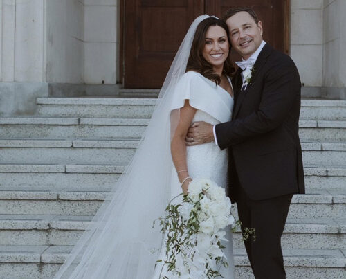 Bride and groom embracing on museum steps.