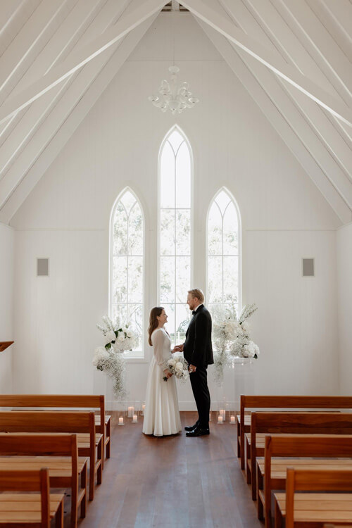 Bride and groom in white empty church.