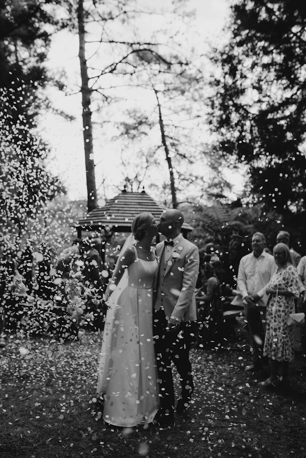 Bride and groom, being showered with confetti.