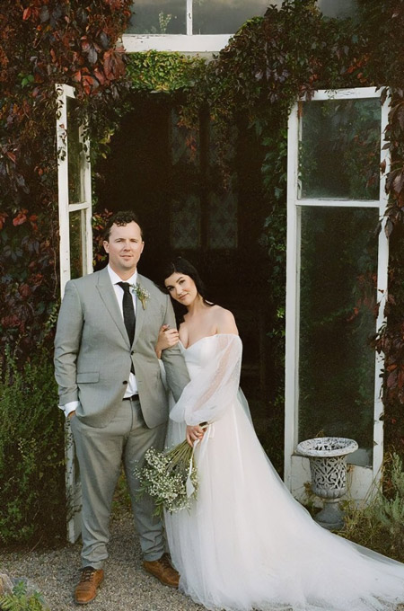 Bride and groom in a rustic garden setting.