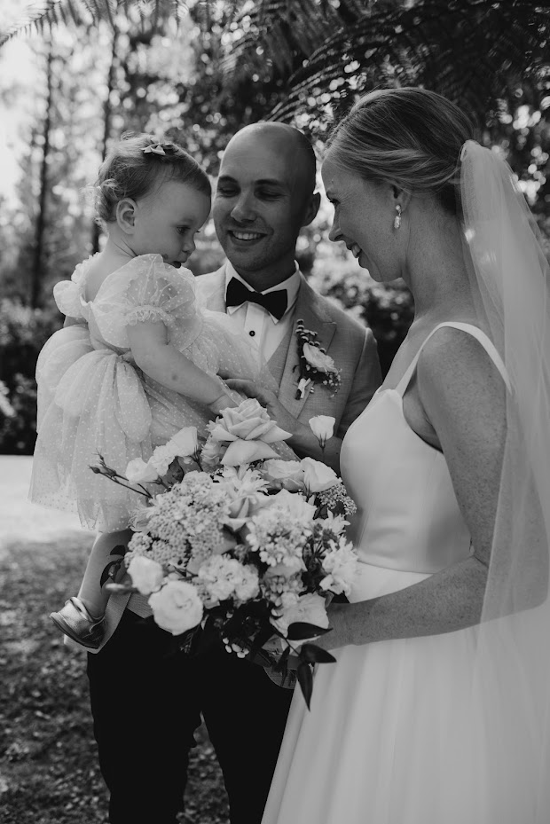 Bride and groom with their cute baby daughter.