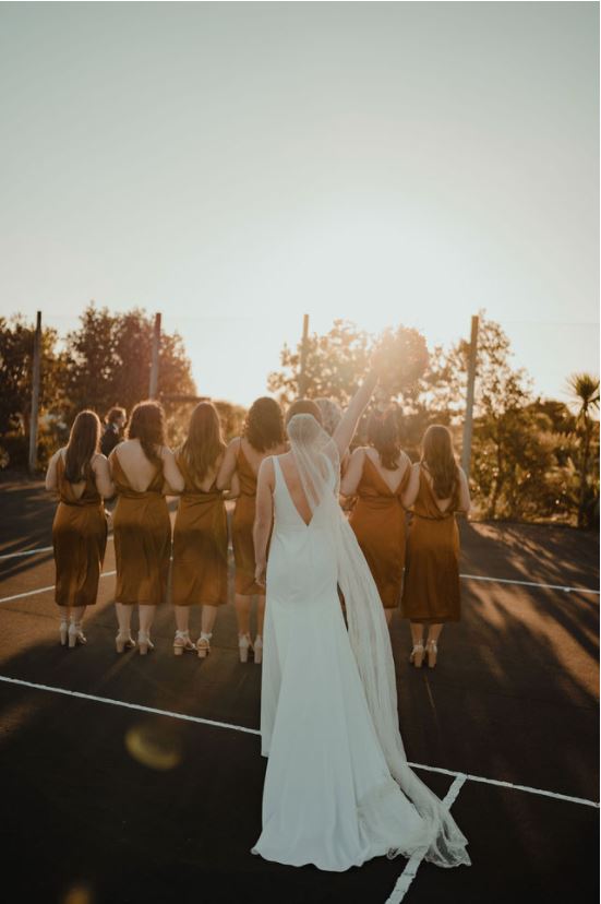 Bride with bridesmaids in copper. Back shot.