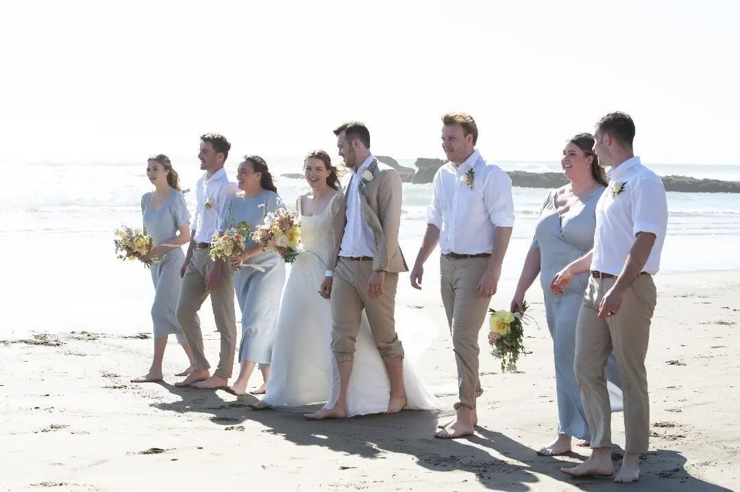 Bridal party walking along the beach.