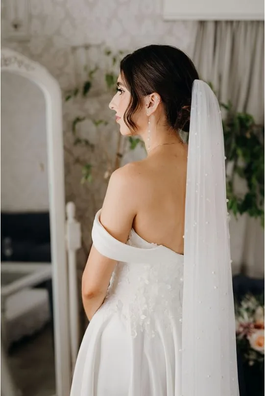 Real bride, wearing an off-the-shoulder wedding dress.