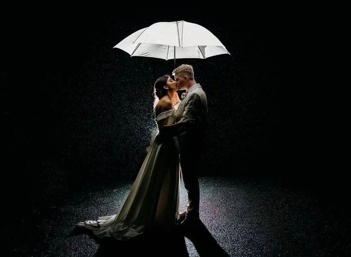 Real bride and groom kissing in the rain.