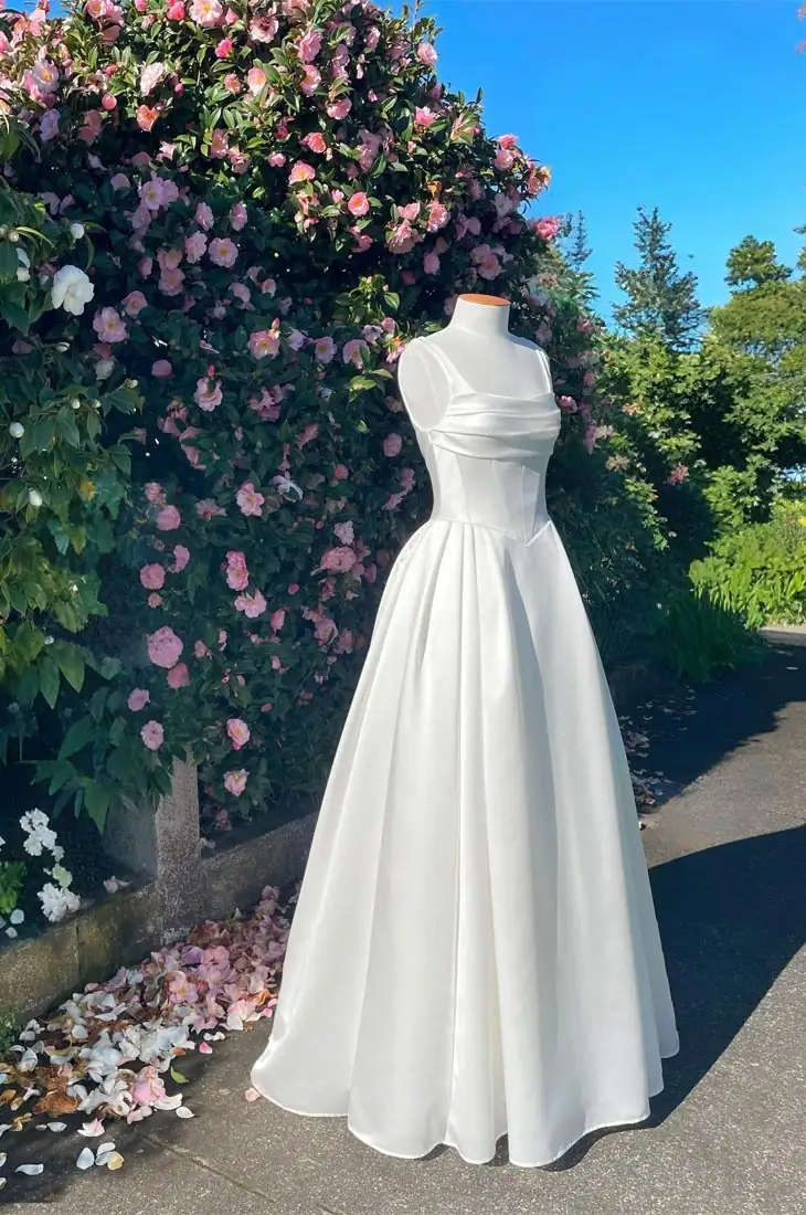 Basque-waist wedding dress with square neckline and pleated full skirt, Auckland, New Zealand.