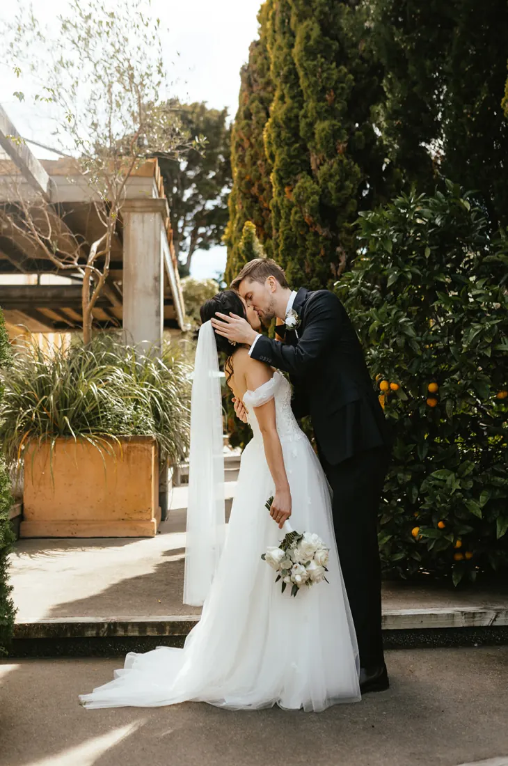 Real bride wearing a tulle wedding dress with 3D floral detail, a soft train and a long veil.
