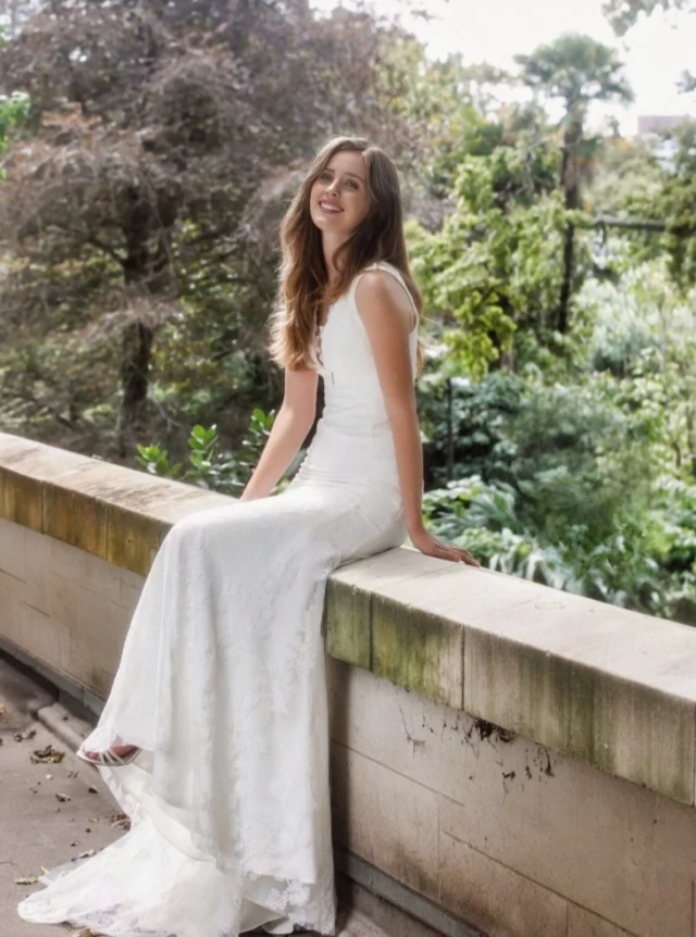 Classic in fit-and-flare lace.

This wedding dress is cut close through the bodice and hip before releasing into a soft flare from the thigh.

The embroidered lace is finished with a light dusting of sequins, giving the surface subtle texture and movement. A plunging front neckline is balanced by a low square back, with wider straps and sheer neckline sections finished with appliquéd lace motifs.

A generous train completes the silhouette.

Each wedding dress purchased keeps a girl in Togo Africa in school for a year.

Wedding Dresses Auckland
Anna Schimmel

#AnnaSchimmel #AucklandWeddings #NZBridal #FitAndFlareWeddingDress #LaceWeddingDress #EmbroideredLace #LowBackWeddingDress