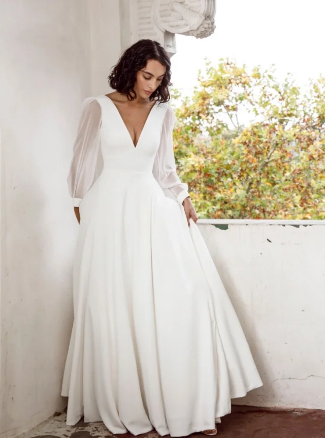 The romance of long sleeves.

There is something wonderfully elegant about a long sleeve wedding dress. This style pairs a clean, flowing silhouette with a deep neckline and beautifully fitted sleeves, creating a look that feels graceful, modern and timeless.

Long sleeves can bring so many different moods to a wedding dress. In smooth crepe they feel sleek and refined, while lace or sheer fabrics can add softness, texture and romance.

Perfect for a winter wedding, a mountain celebration, or simply because you love the look.

Designed by Anna Schimmel in Auckland.

#WeddingDress #LongSleeveWeddingDress #WeddingDressesNZ #NZBride #AucklandWeddingDress #BridalStyle