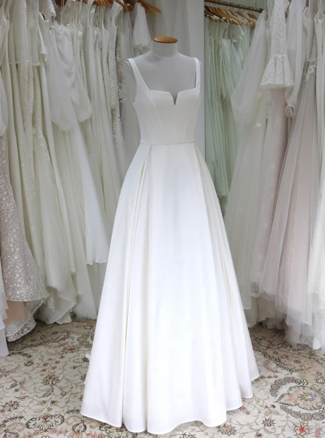 There is something incredibly striking about a beautifully simple wedding dress.

If you love clean, uncomplicated styles but worry that a simple gown might not feel special enough, often the opposite is true.

Clean lines frame the bride rather than compete with her, allowing beautiful fabric, thoughtful proportions and an immaculate fit to take centre stage. The result can feel elegant, confident and wonderfully timeless.

Featured here is Sophia, a classic wedding dress in soft ivory duchess satin, with a structured panelled bodice, square neckline, fitted waist and full A-line skirt finished with crisp box pleats.

Simple, yes. But certainly not ordinary.

#SimpleWeddingDress #ClassicWeddingDress #SatinWeddingDress #AlineWeddingDress #WeddingDressesNZ #NZBride